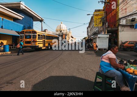 Ein umfunktionierten US-Schulbus im Stadtzentrum von San Salvador, El Salvador. Die Metropolitan Cathedral ist dahinter zu sehen Stockfoto