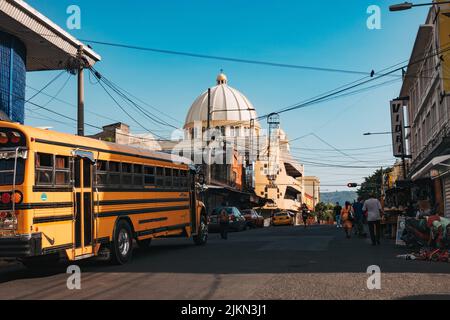 Ein umfunktionierten US-Schulbus im Stadtzentrum von San Salvador, El Salvador. Die Metropolitan Cathedral ist dahinter zu sehen Stockfoto