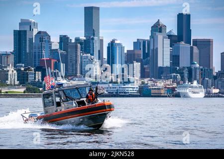 Ein 29-Fuß-Sicherheitsboot – eine kleine Besatzung der Küstenwache von Seattle setzt während der jährlichen Flottenwoche und des Seafair Festivals in Seattle am 1. August 2022 eine Sicherheitszone bei einer Parade von Schiffen durch. Mehrere Küstenwache-Cutter-Crews aus der Region Puget Sound schlossen sich während der Parade entlang der Küste von Seattle zwei Marineschiffen und zwei Schiffen der Royal Canadian Navy an. (USA Foto der Küstenwache von Petty Officer, Klasse 1., Travis Magee) Stockfoto