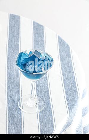 Nahaufnahme eines eisblauen Cocktails im Glas auf einem Tisch Stockfoto