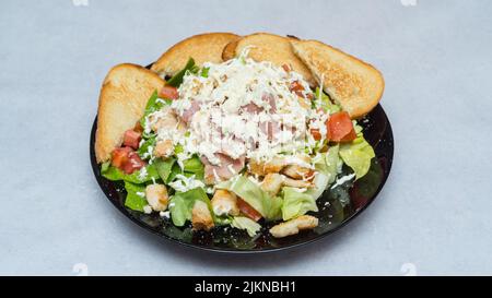 Ein Teller mit einem Caesar-Salat, isoliert auf einem weißen Hintergrund Stockfoto