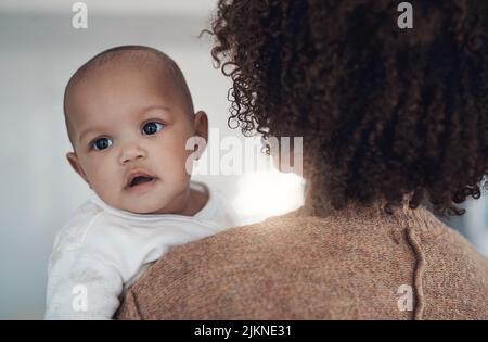 Ich habe Sonnenschein auf meinen Schultern. Eine junge Frau trägt ihr entzückendes Mädchen zu Hause. Stockfoto