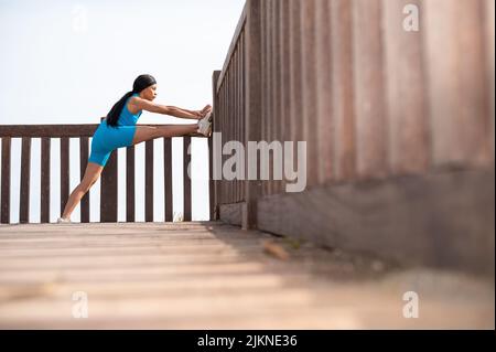 Eine hübsche afroamerikanische Frau, die an einem sonnigen Tag am Strand Sport macht Stockfoto