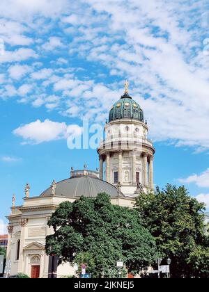 Eine schöne Aufnahme der Neuen Kirche (Deutscher Dom) gegen den blauen Himmel an einem schönen sonnigen Tag im Gendarmenmarkt, Berlin, Deutschland Stockfoto