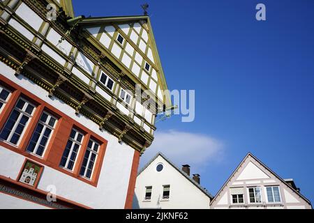 Ein niedriger Winkel von einem grünen und roten Fachwerkgebäude mit blauem Himmel Stockfoto