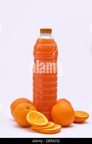 Ganze und geschnittene Orangen mit gepresstem Saft auf weißem Hintergrund Stockfoto