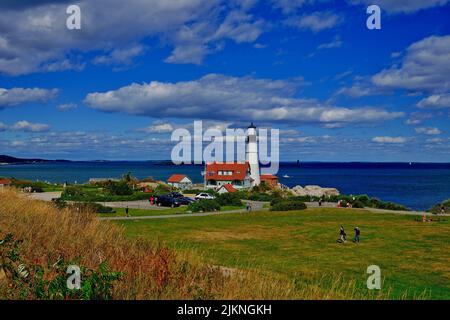 Das berühmte Portland Head Light, ein Leuchtturm in Cape Elizabeth, über einem Hintergrund des blauen Ozeans unter einem bewölkten Himmel, Maine Stockfoto