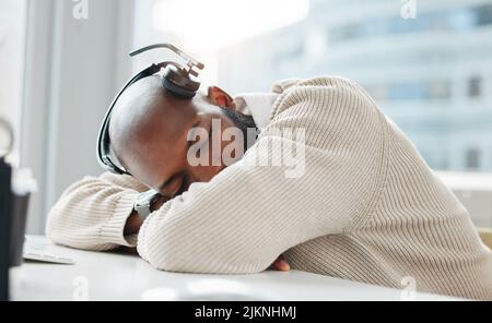 Ein kleines Nickerchen könnte mir etwas Gutes tun. Ein hübscher junger Geschäftsmann schläft tagsüber auf seinem Schreibtisch. Stockfoto