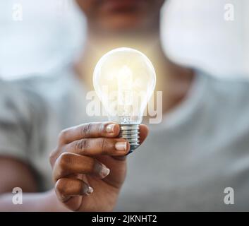 Nutzen Sie Ihr Wissen, um Licht in diese Welt zu bringen. Eine unkenntliche Geschäftsfrau, die eine Glühbirne hält. Stockfoto