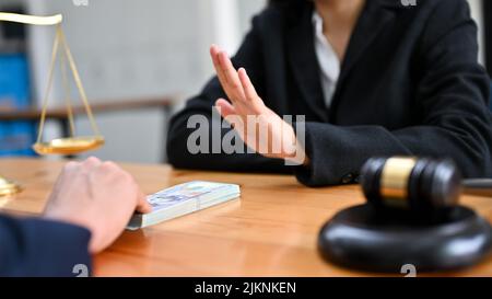 Eine Rechtsanwältin oder Unternehmensberaterin weigert sich, eine Bestechung von ihrem Mandanten zu nehmen. Anti-Korruptions-Konzept. Nahaufnahme Bild Stockfoto