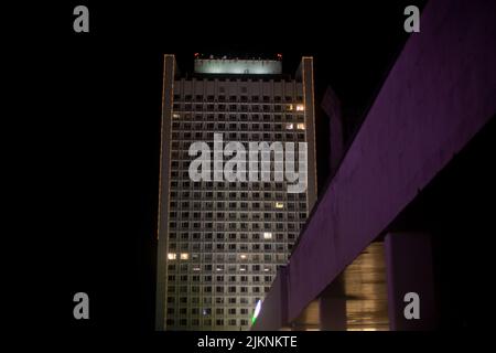 Gebäude ist nachts. Bürogebäude mit vielen Fenstern. Licht der Fenster im großen Haus. Stockfoto