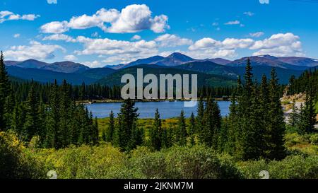 Der wolkenblaue Himmel über den grünen Hügeln und der blaue See im Frühling Stockfoto