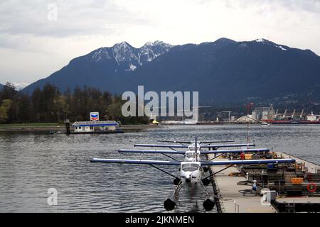 Die Reihe von Wasserflugzeugen in der Nähe des Anlegestelle gegen die Bergkette. Vancouver, British Columbia, Kanada. Stockfoto