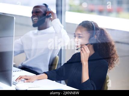 Unsere freundlichen Mitarbeiter stehen Ihnen gerne zur Seite. Eine junge Geschäftsfrau, die in einem Callcenter arbeitet. Stockfoto