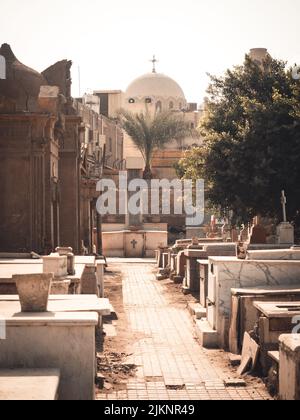 Eine vertikale Aufnahme eines christlichen Friedhofs mit einer Kuppel am Horizont an einem schönen sonnigen Tag in Assuan, Ägypten Stockfoto