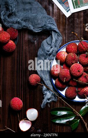 Eine vertikale Nahaufnahme der Lychee-Früchte auf dem Holztisch. Draufsicht. Stockfoto