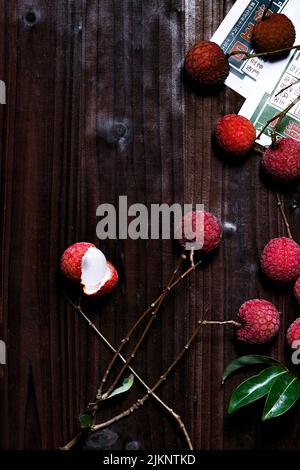 Eine vertikale Nahaufnahme der Lychee-Früchte auf dem Holztisch. Draufsicht. Stockfoto