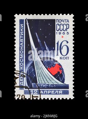 Kosmonauten-Denkmal (Rakete) in Moskau, um 1965. Nationaler Kosmonauten-Tag. Abgesagte Vintage-Briefmarke der UdSSR isoliert auf schwarzem Hintergrund. Stockfoto