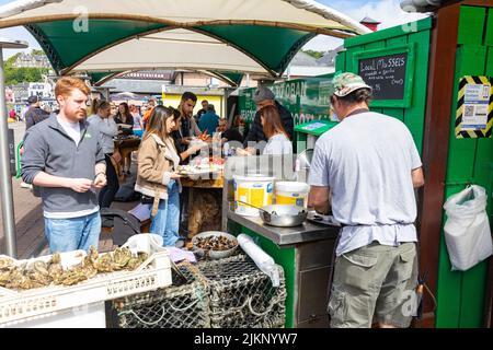 Oban Resort Stadt und Kai, grüne Hütte Verkauf von frischen Meeresfrüchten und Schalentieren an Kunden, Oban, Argyll, Schottland an sonnigen Sommertag 2022 Stockfoto