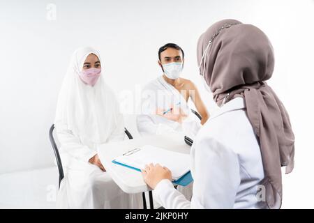 Der Arzt in einer Maske fragt die angehenden Pilger der Pilgergruppe Stockfoto