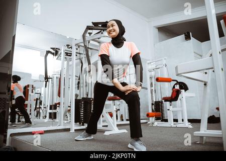 Sportmädchen lächelt Stretching ihren Körper in der Turnhalle, Lebensstil, gesunden Lebensstil. Stockfoto