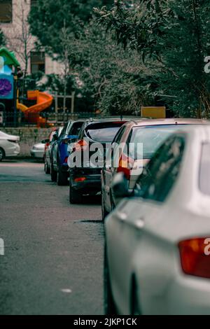 Die Reihe geparkter Autos auf der Straße gegen den Spielhof in Istanbul, Türkei Stockfoto