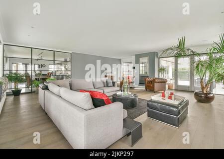 Quadratischer Tisch auf einer Matte in der Nähe von Couch und TV im stilvollen Wohnzimmer der modernen Wohnung platziert Stockfoto