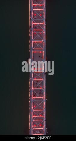 Eine Luftaufnahme einer Brücke, die nachts von den Lichtern beleuchtet wird Stockfoto