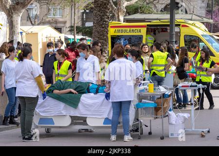 Ein Ambulanzwagen mit dem Personal und ein Patient auf der Bahre liegend, mit Menschen, die sich versammelt hatten Stockfoto