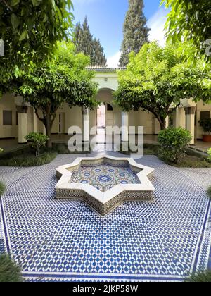 Leerer Mosaikhof mit einem kleinen Brunnen in der Mitte Stockfoto