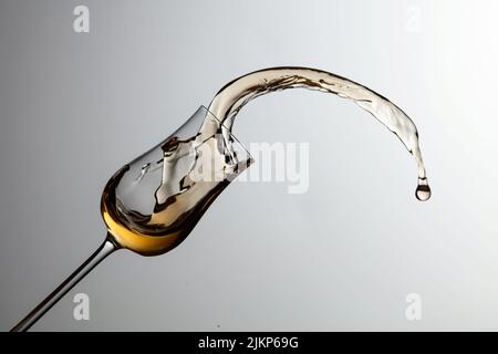 Das Getränk wird aus dem Glas verschüttet. Konzept des Themas Premium-Alkohol. Speicherplatz kopieren. Stockfoto