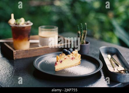 Eine Nahaufnahme eines Stückes Kuchen auf schwarzem Teller Stockfoto