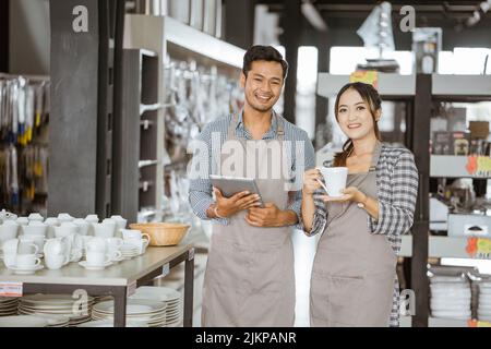 Junge und Mädchen tragen Schürzen mit Polster und einer Tasse Stockfoto