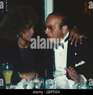 Whitney Houston und Clive Davis nehmen am 17. März 1990 an der Arista AIDS Party in Tavern on the Green in New York City Teil. Foto: Henry McGee/MediaPunch Stockfoto