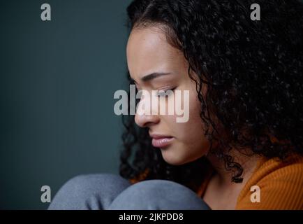 So viele leiden still. Eine junge Frau fühlt sich zu Hause unglücklich. Stockfoto