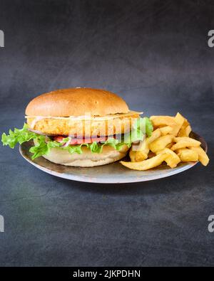 Nahaufnahme eines Chicken Burger mit pommes auf einem Teller. Stockfoto