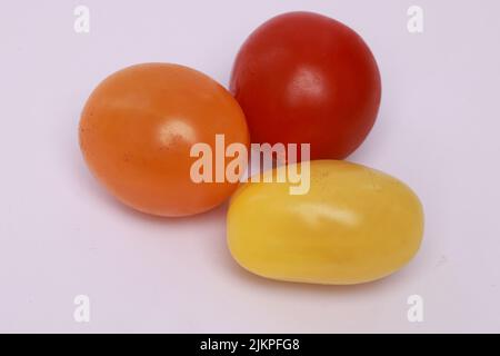 Eine Nahaufnahme von bunten Kirschtomaten, isoliert auf weißem Hintergrund Stockfoto