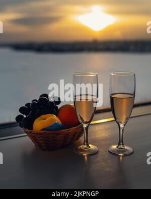 Zwei Gläser mit Champagner am Fenster bei Sonnenuntergang Stockfoto
