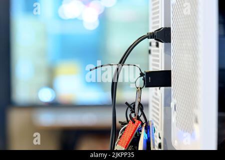 Selektiver Fokus schwarzes USB 3,0-Flash-Laufwerk mit USB-Anschluss auf der Hauptplatine des Computers des PC-Desktops verbinden, um Daten auf verschwommenem Hintergrund zu übertragen Stockfoto