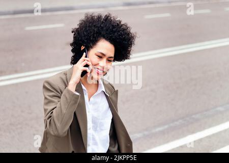 Lächelnde Geschäftsfrau, die am Telefon spricht Stockfoto