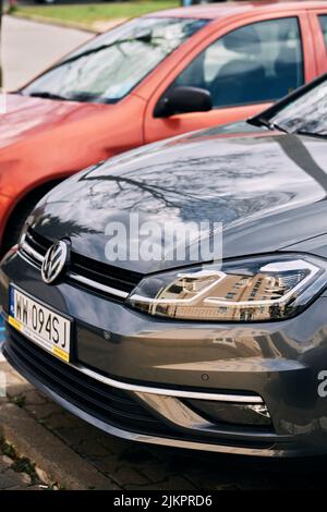 Eine vertikale Aufnahme des vorderen Teils eines geparkten neuen Volkswagen Golf Autos. Stockfoto