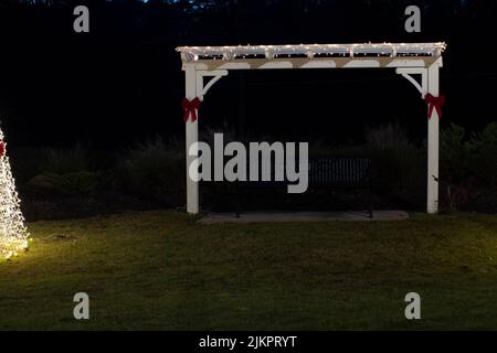 Augusta, GA USA - 01 14 22: Eine Parkbank während der Weihnachtszeit in der Nacht Stockfoto