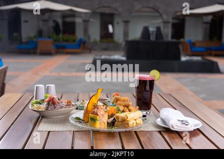 Auf dem Kaffeetisch im Freien werden Snacks, Salat und Saft serviert Stockfoto