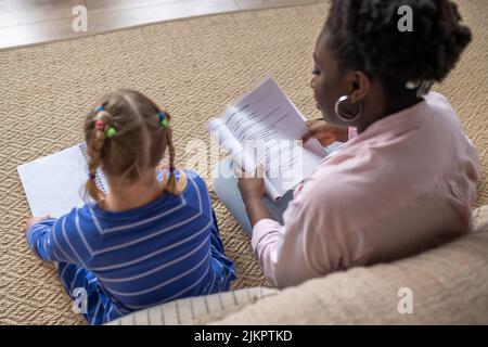 Ein Mädchen mit Down-Syndrom, das mit ihrem Lehrer etwas liest Stockfoto