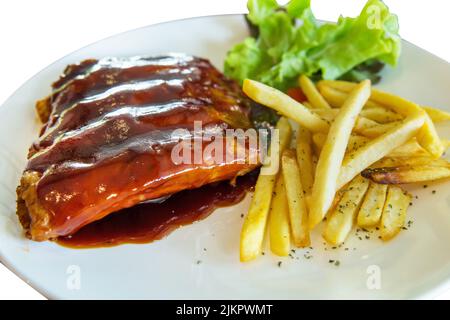 Gestanzt aus Grill-Schweinestrippen mit pommes auf weiß isoliert. Stockfoto