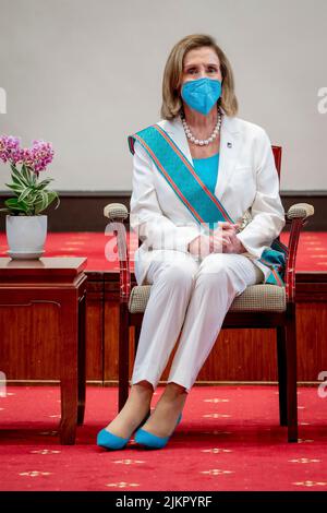 Taipeh, Taiwan. 03. August 2022. Die US-Sprecherin des Repräsentantenhauses, Nancy Pelosi, trägt den Orden der günstigen Wolke und hört zu, wie der taiwanesische Präsident Tsai Ing-wen, während einer Begrüßungszeremonie im Präsidentenamt am 3. August 2022 in Taipei, Taiwan, eine Rede hält. Pelosi führt eine Delegation von Kongressführern bei einem Besuch an, der China verärgert hat. Kredit: Makoto Lin/Taiwan Präsidentenamt/Alamy Live Nachrichten Stockfoto