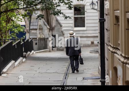 Ein Mann mit einem Trilby-Hut und Aktentasche geht die Temple Middle Lane entlang, einem der wichtigsten Rechtsviertel in London und ein bemerkenswertes Zentrum für Recht. Stockfoto