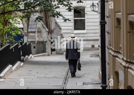 Ein Mann mit einem Trilby-Hut und Aktentasche geht die Temple Middle Lane entlang, einem der wichtigsten Rechtsviertel in London und ein bemerkenswertes Zentrum für Recht. Stockfoto