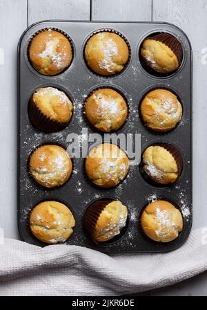 Backblech mit gebackenen Muffins auf weißem Hintergrund. Stockfoto