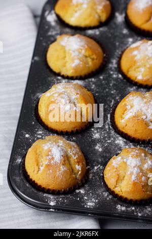 Backblech mit gebackenen Muffins auf weißem Hintergrund. Stockfoto